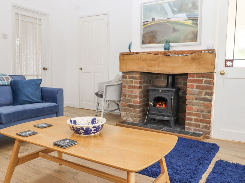 A living room with a fireplace and sofa at Greengates in Rye
