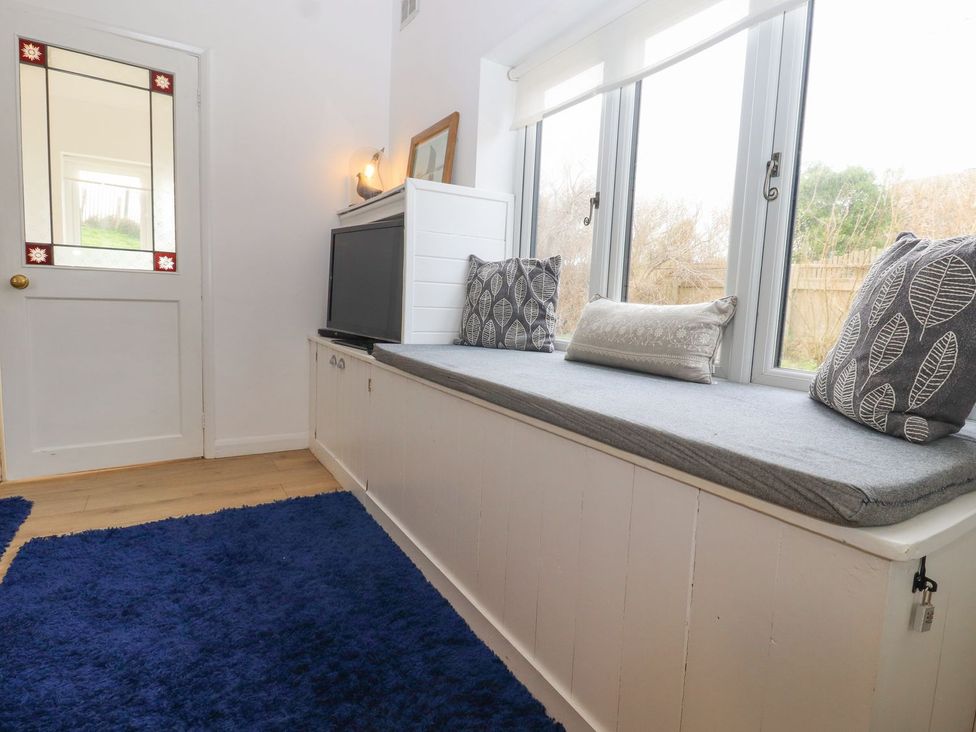 A snug with a window seat and television at Greengates in Rye