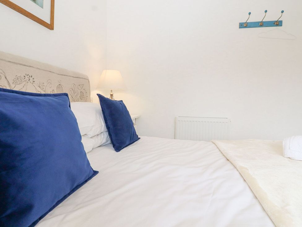 A bedroom with a bed and blue pillows at Greengates, Rye