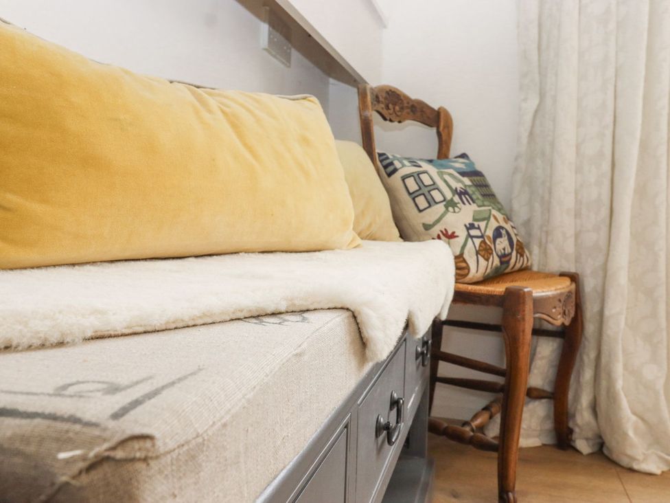 A living room with a bench and decorative cushions at Greengates in Rye