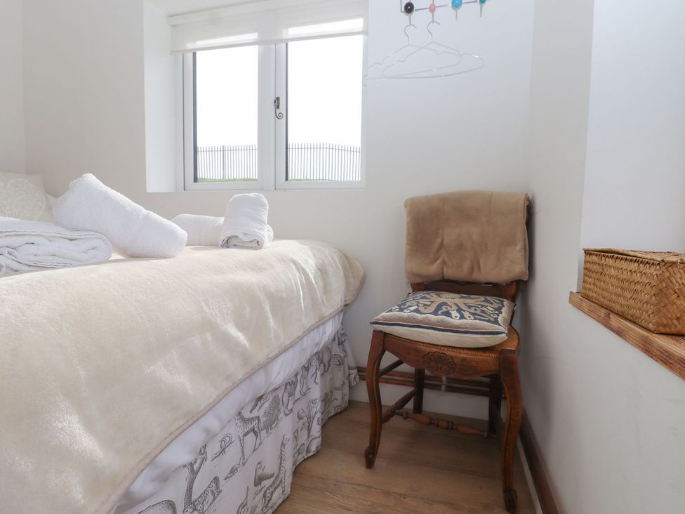 A bedroom with a bed and chair at Greengates in Rye