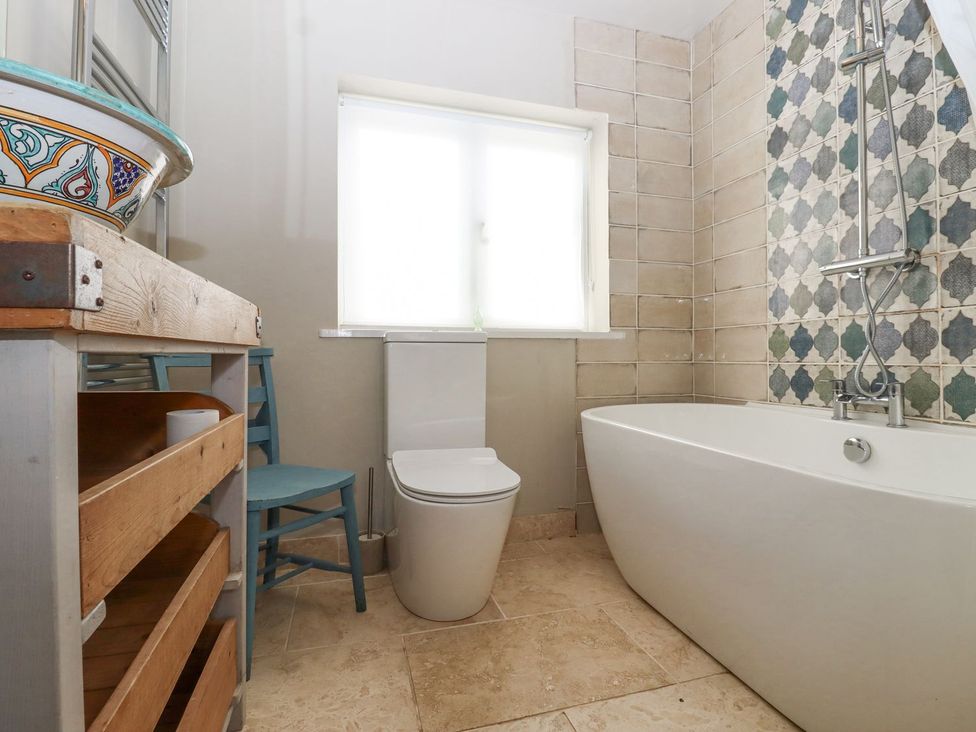 A bathroom featuring a bathtub, a toilet, and a decorative sink at Greengates, Rye