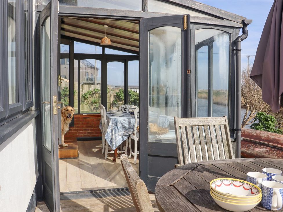 A conservatory with a table and chairs at Greengates in Rye