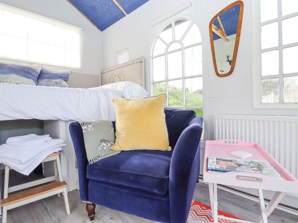 A bedroom with a bed and chair at Greengates in Rye
