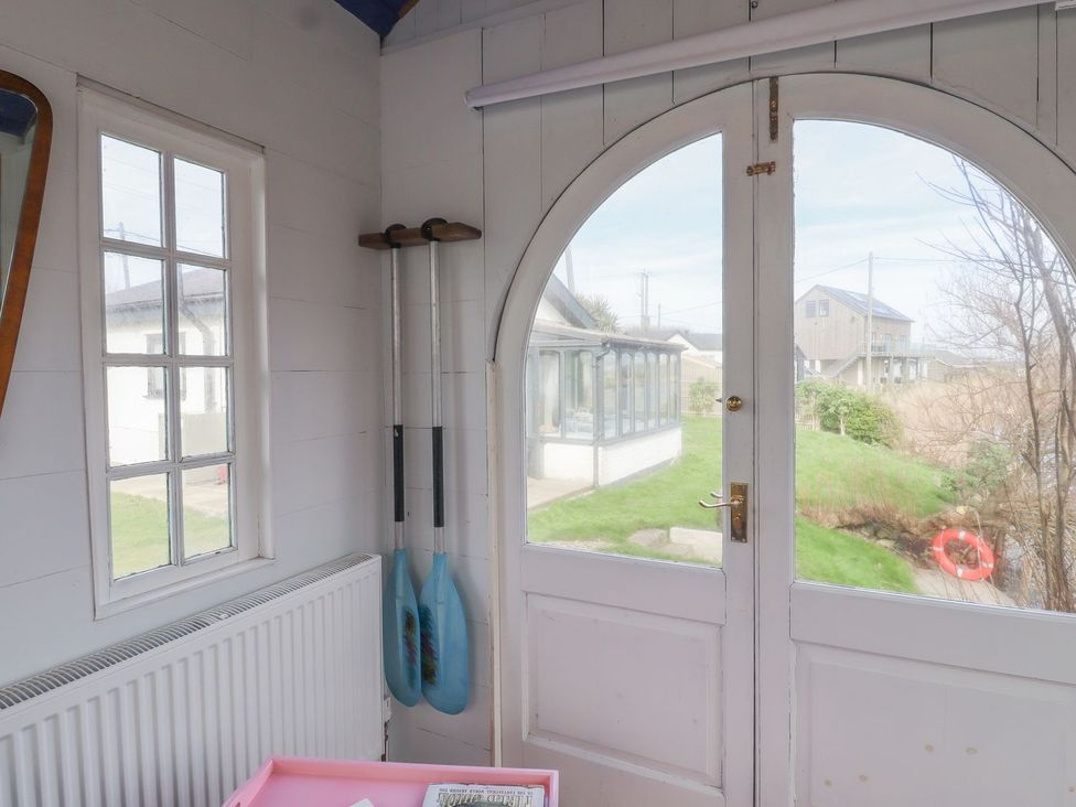 A sunroom with a door and paddles at Greengates in Rye