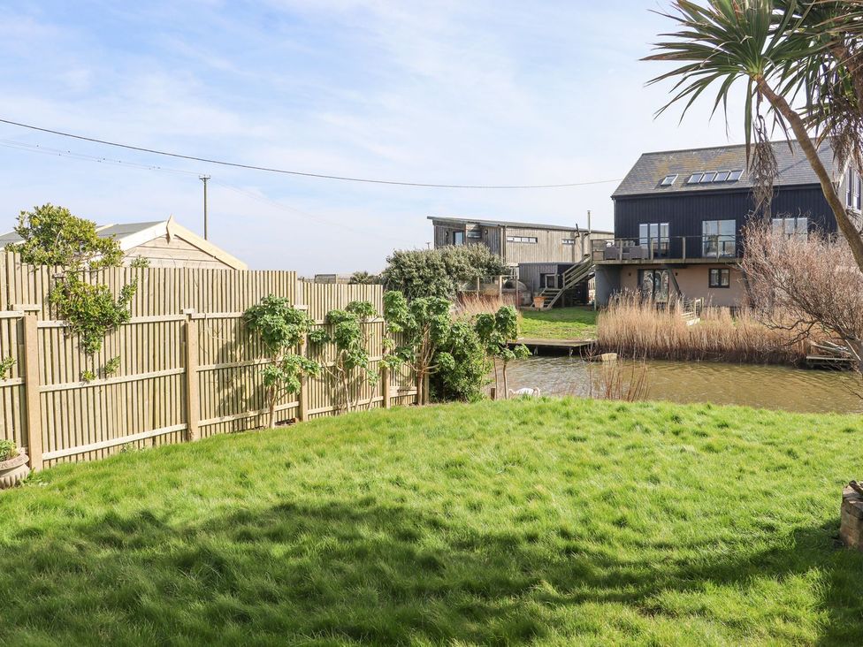 A garden with grass and water at Greengates in Rye