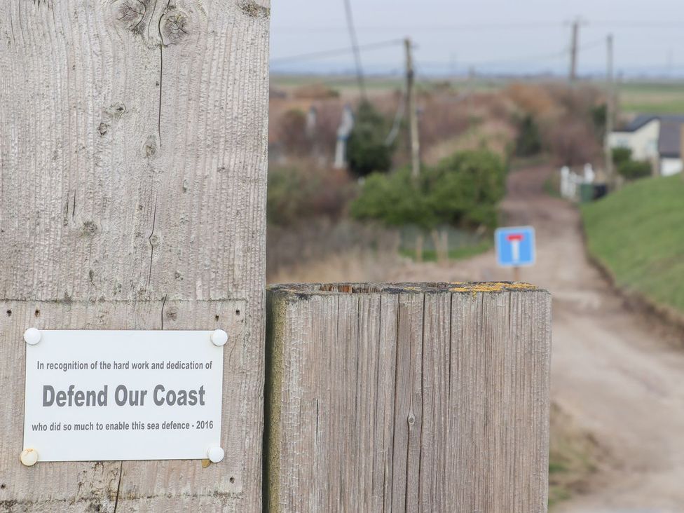 A wooden sign and a road leading into the distance at Greengates in Rye