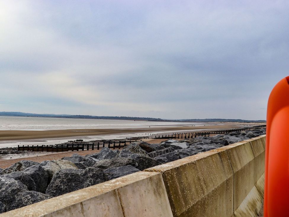 A view of the beach with rocks and wooden posts at Greengates in Rye