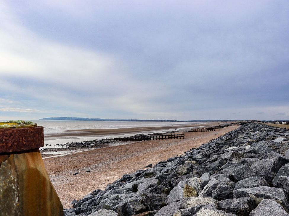 A beach view with rocks and a pier at Greengates in Rye