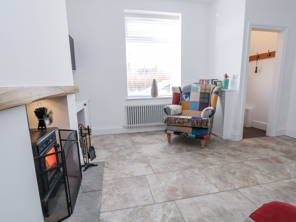A living room with a fireplace and armchair at 10 South Street Rossendale