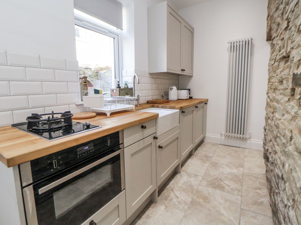 A kitchen with cabinets, oven, gas stove, and sink at 10 South Street, Rossendale