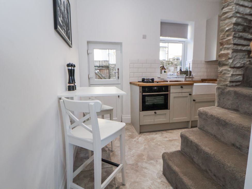A kitchen with a counter and stairs at 10 South Street in Rossendale