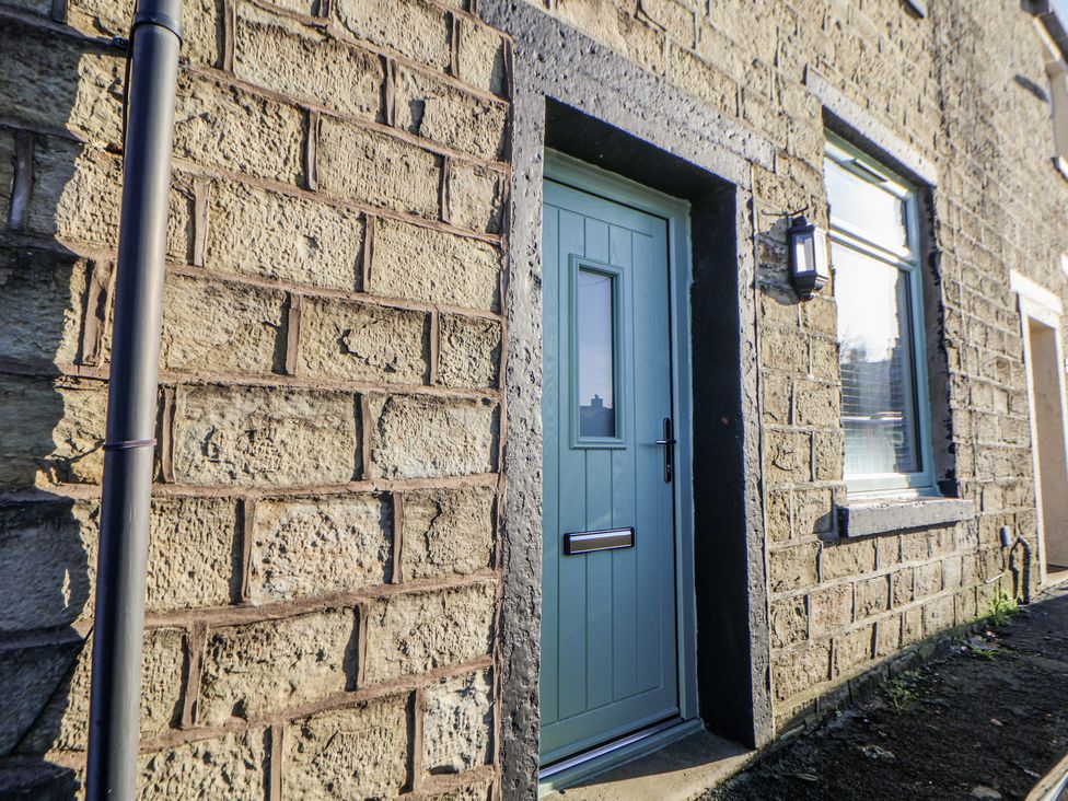 An entrance door with stone wall and window at 10 South Street in Rossendale