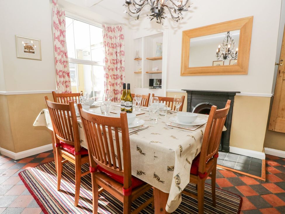 A dining room with a table set for dinner at The Burrow in Windermere