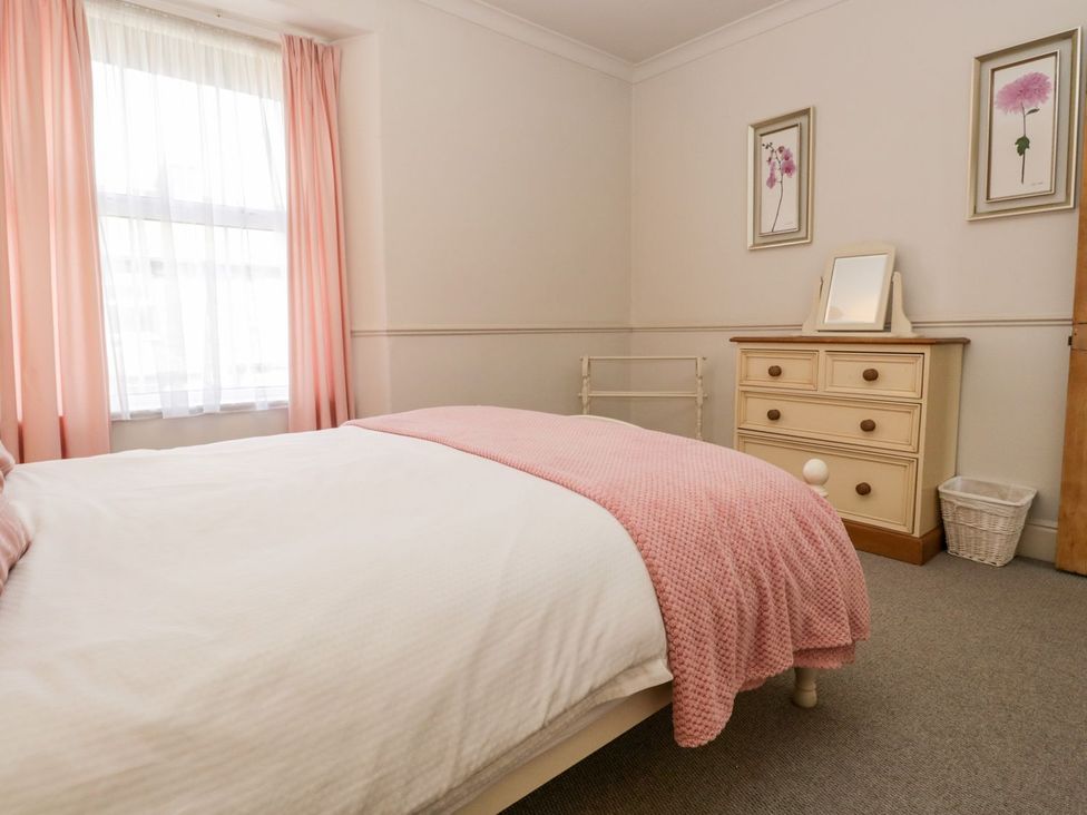 A bedroom with a bed and dresser at The Burrow in Windermere