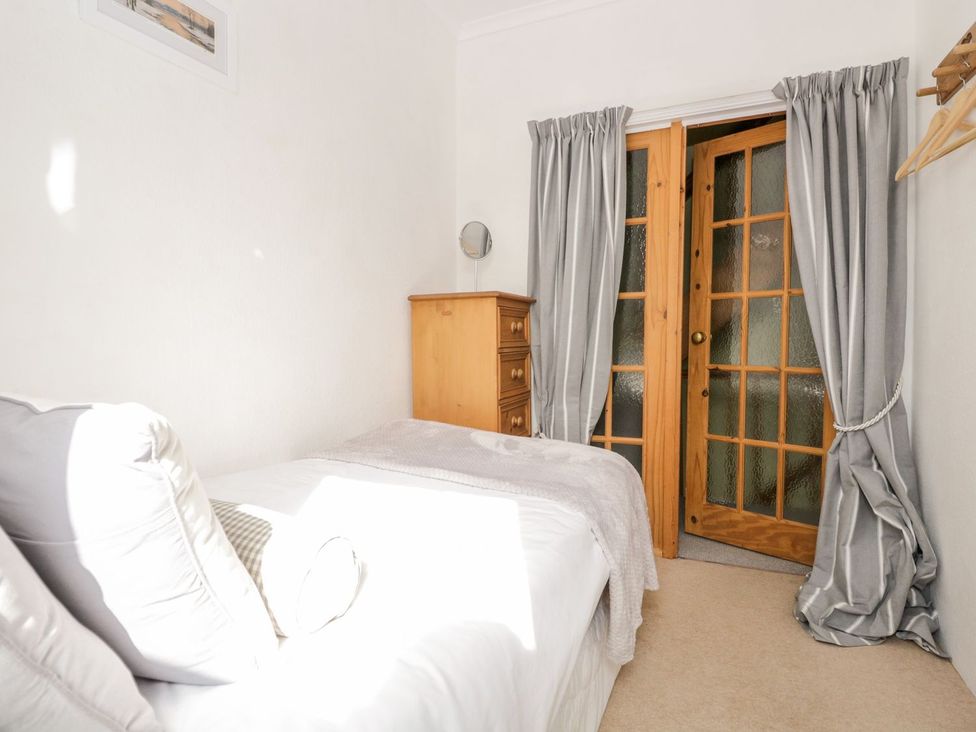A bedroom with a bed and a wooden dresser at The Burrow in Windermere