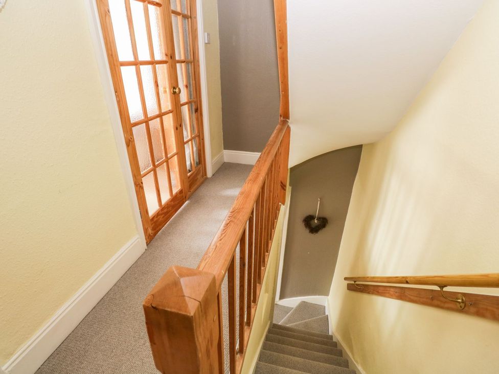 A staircase leading down to a hallway at The Burrow in Windermere