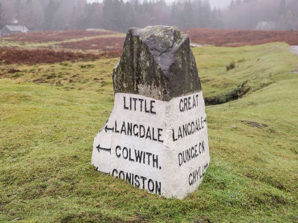 A directional stone sign indicating locations at The Burrow in Windermere