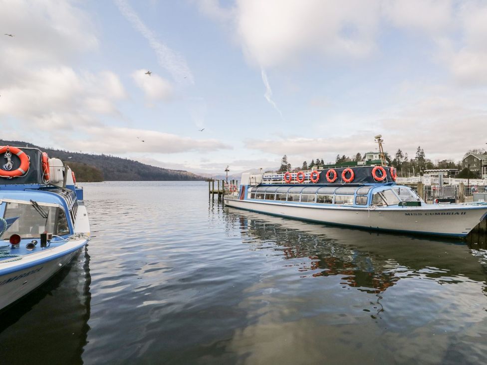 Two boats docked at a pier on a lake at The Burrow in Windermere