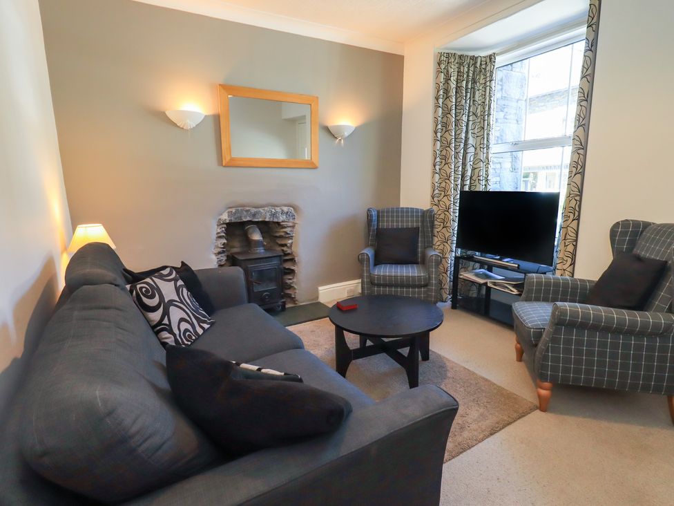 A living room with a sofa and armchairs at The Burrow in Windermere