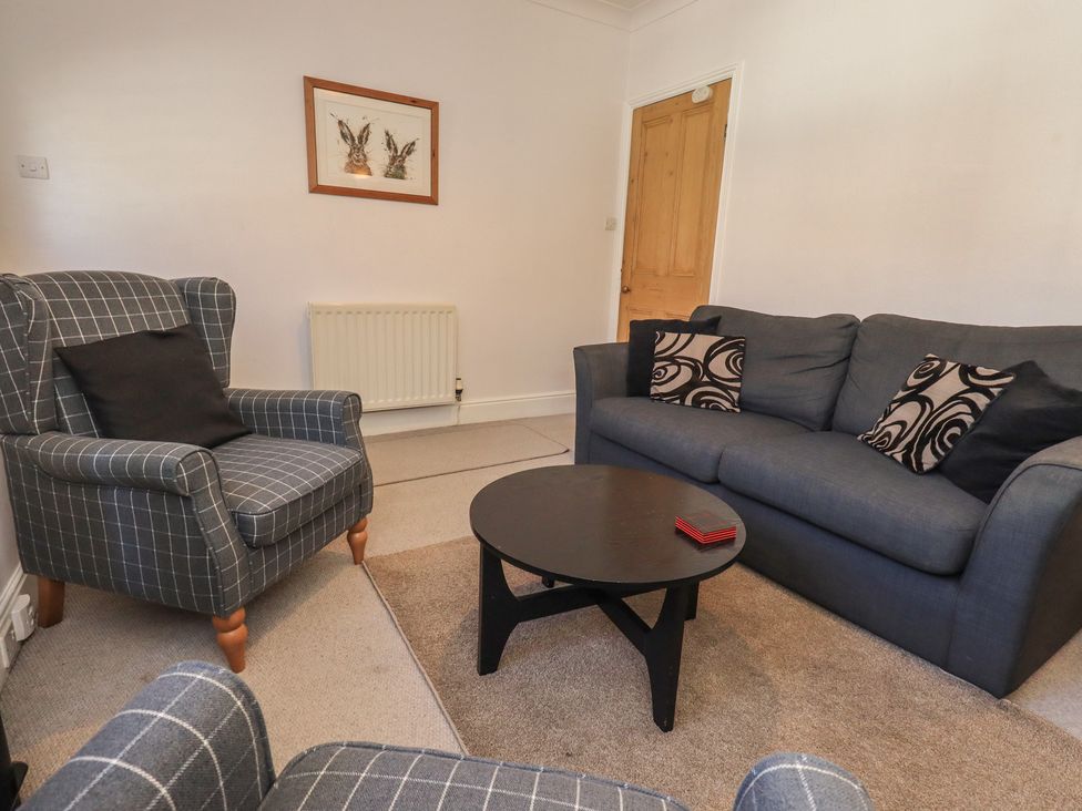A living room with a sofa and armchair at The Burrow in Windermere