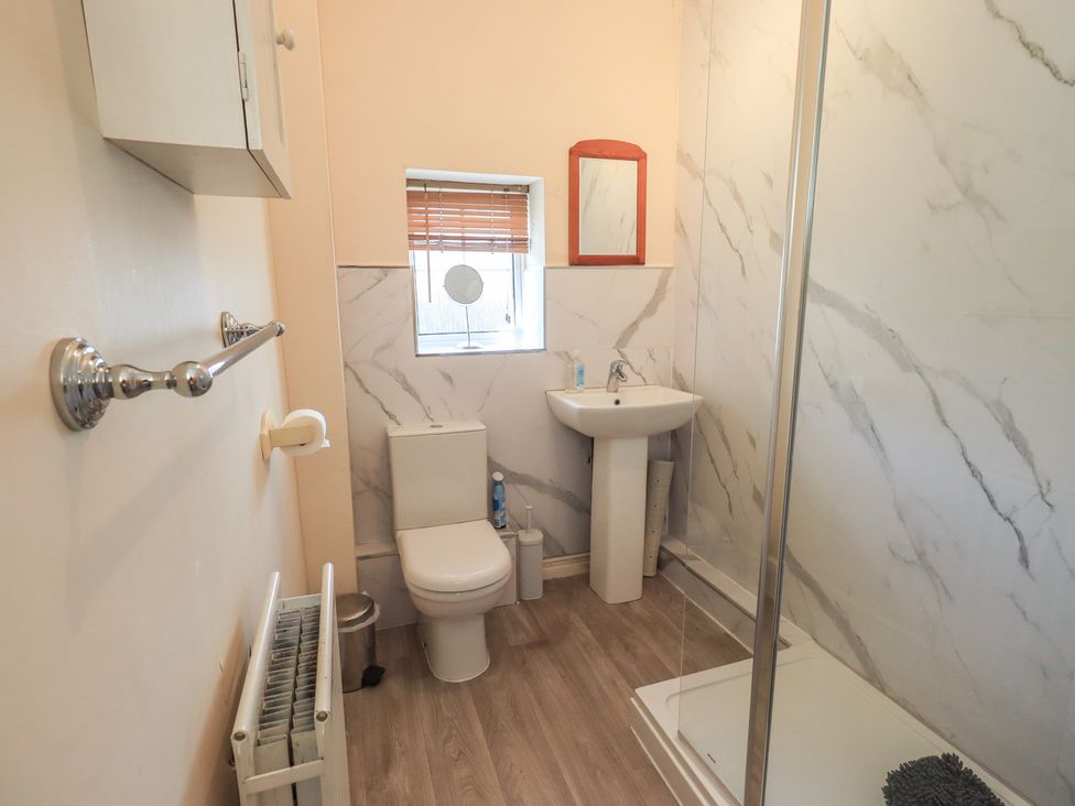 A bathroom with shower, sink, and toilet at The Burrow in Windermere