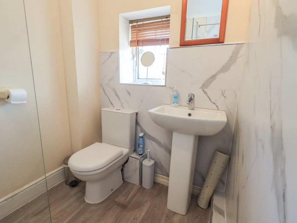 A bathroom featuring a toilet and sink with a mirror at The Burrow in Windermere
