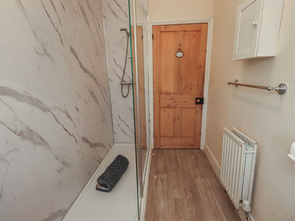A bathroom with a shower and towel rack at The Burrow in Windermere