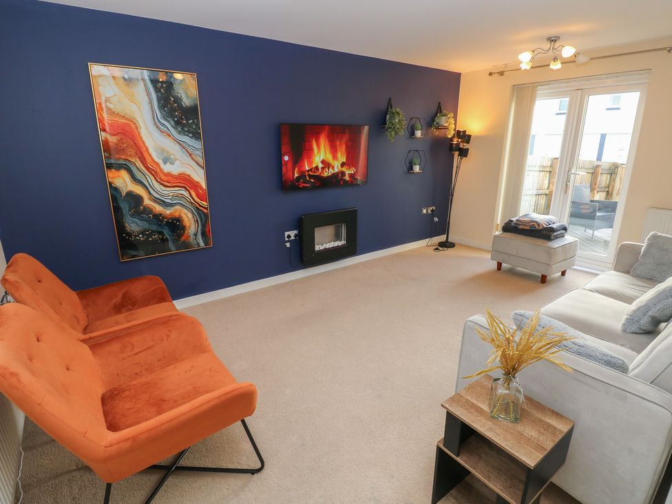 A living room with a fireplace and television at 9 Ffordd Donaldson in Swansea