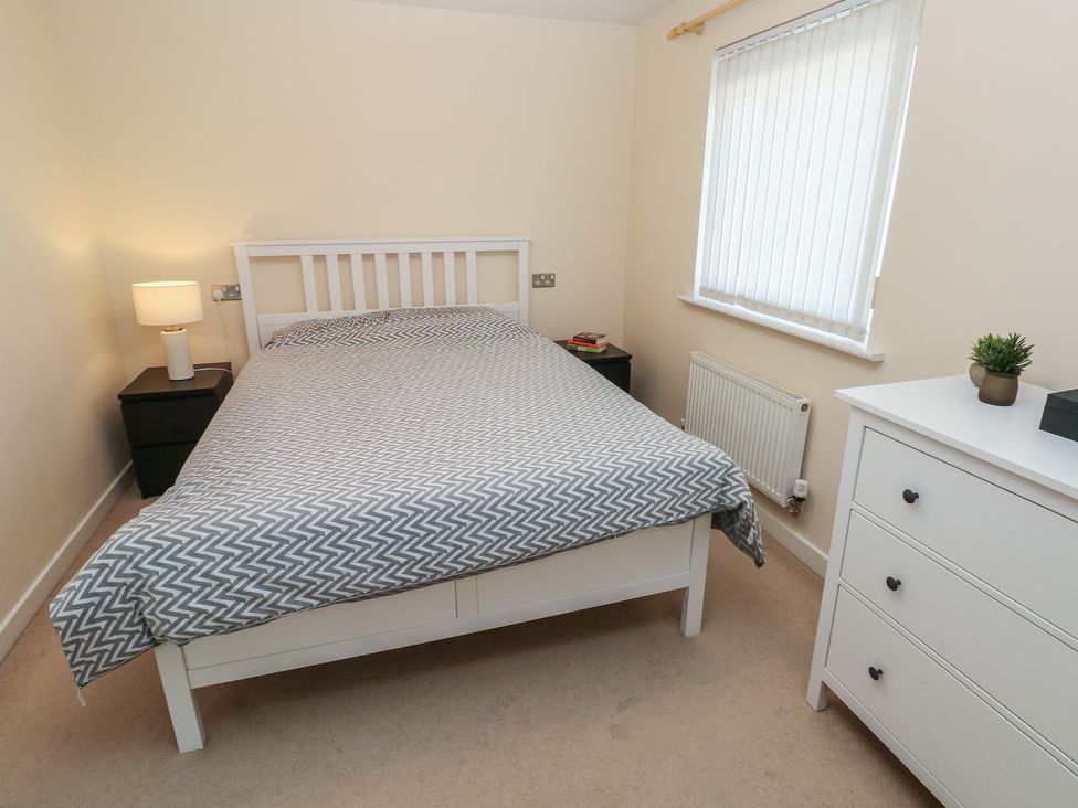 A bedroom with a bed and lamp at 9 Ffordd Donaldson in Swansea