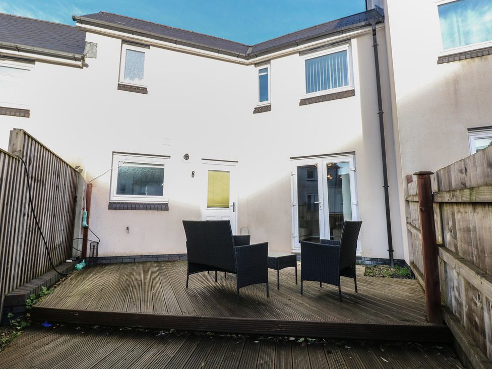 A backyard with decking and seating area at 9 Ffordd Donaldson Swansea