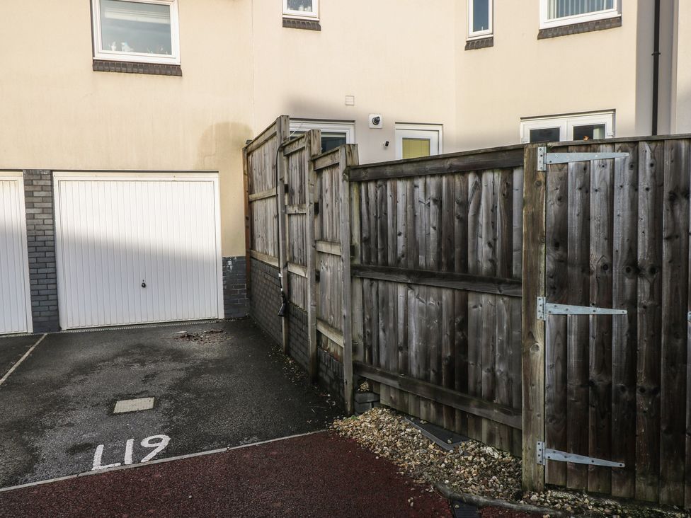 An outdoor area with a garage door and a wooden fence at 9 Ffordd Donaldson Swansea