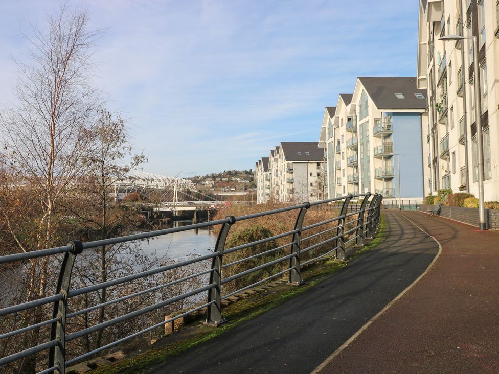 A path along water with buildings and trees at 9 Ffordd Donaldson Swansea