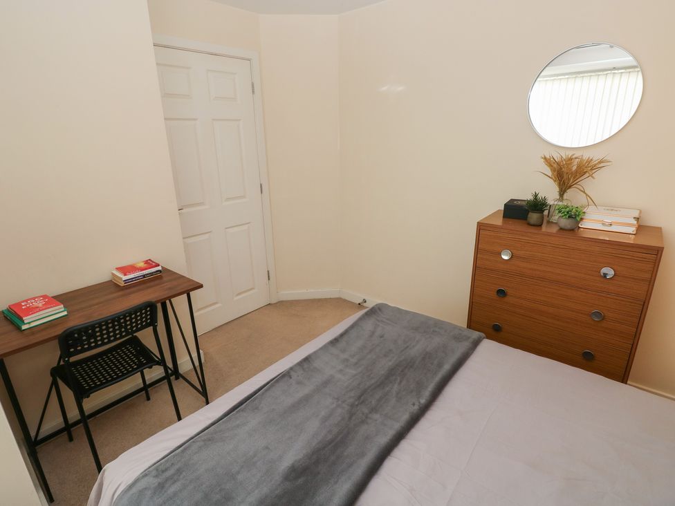 A bedroom with a bed, desk, chair, and dresser at Swansea Escape in Swansea