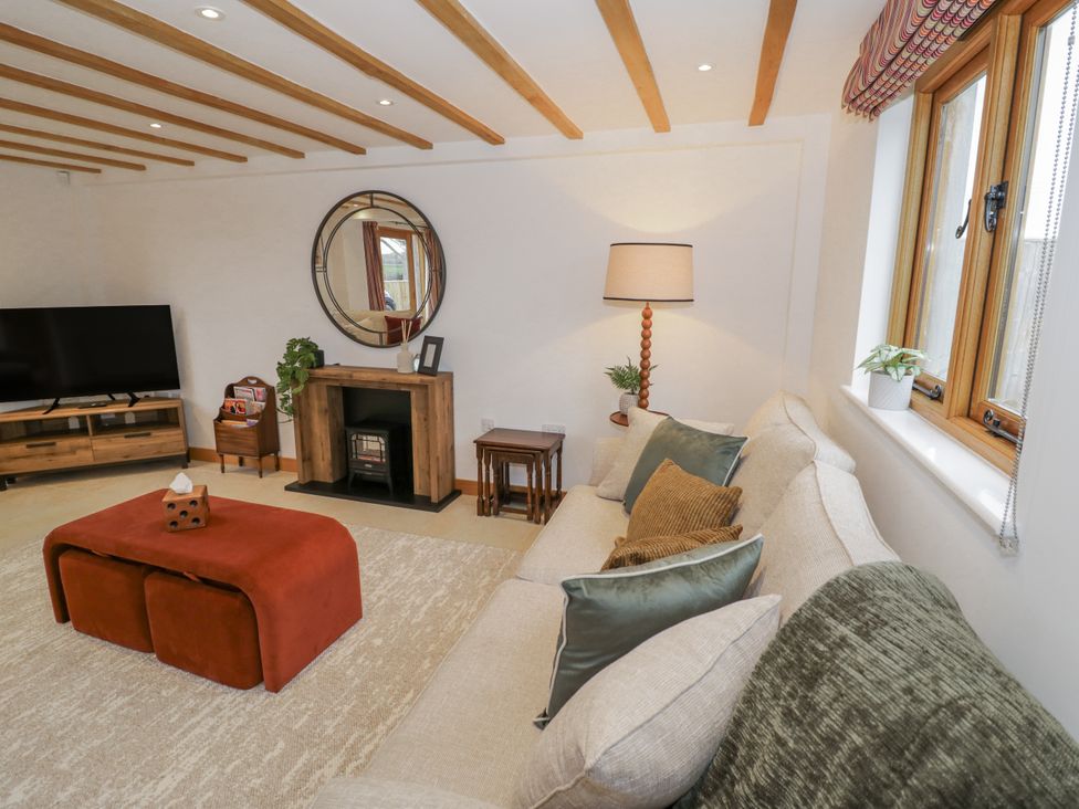 A living room with a television and sofa at Cedar Barn