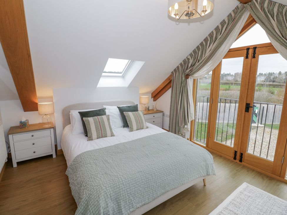 A bedroom with a bed and nightstands at Cedar Barn