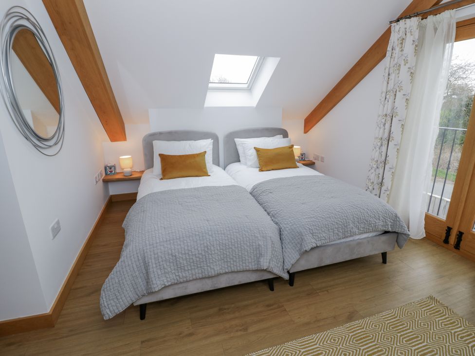 A bedroom with two beds and a window at Cedar Barn