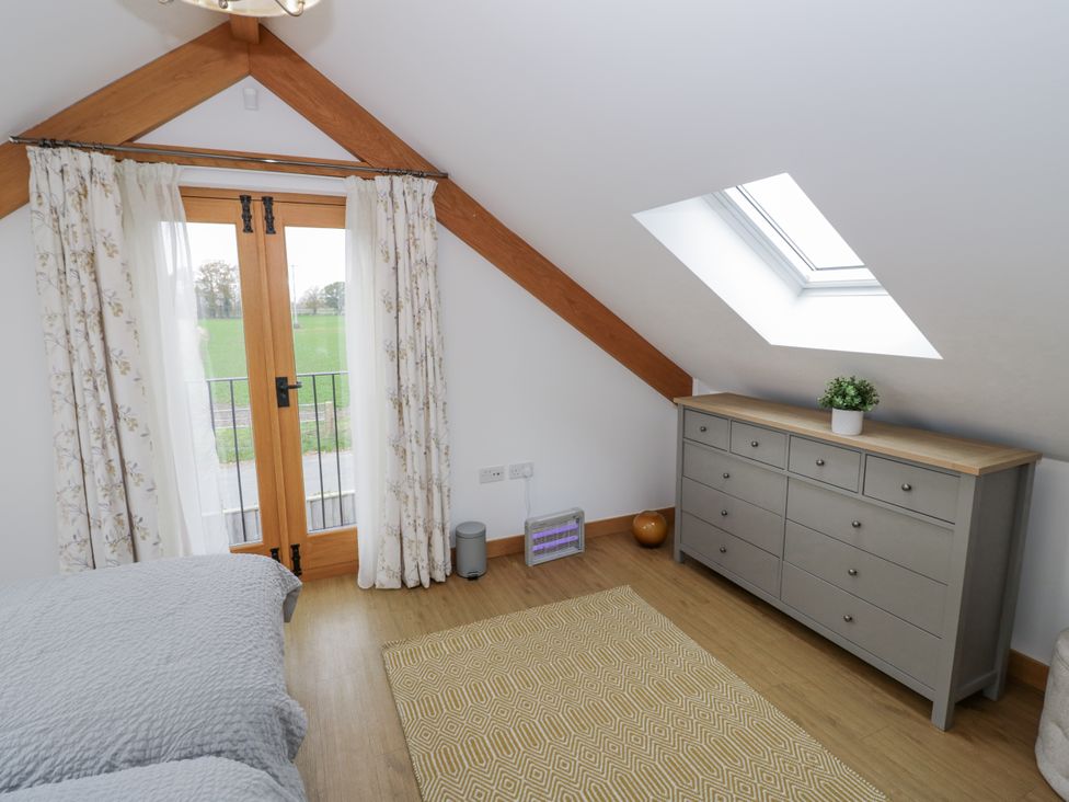 A bedroom with a dresser and double bed at Cedar Barn 