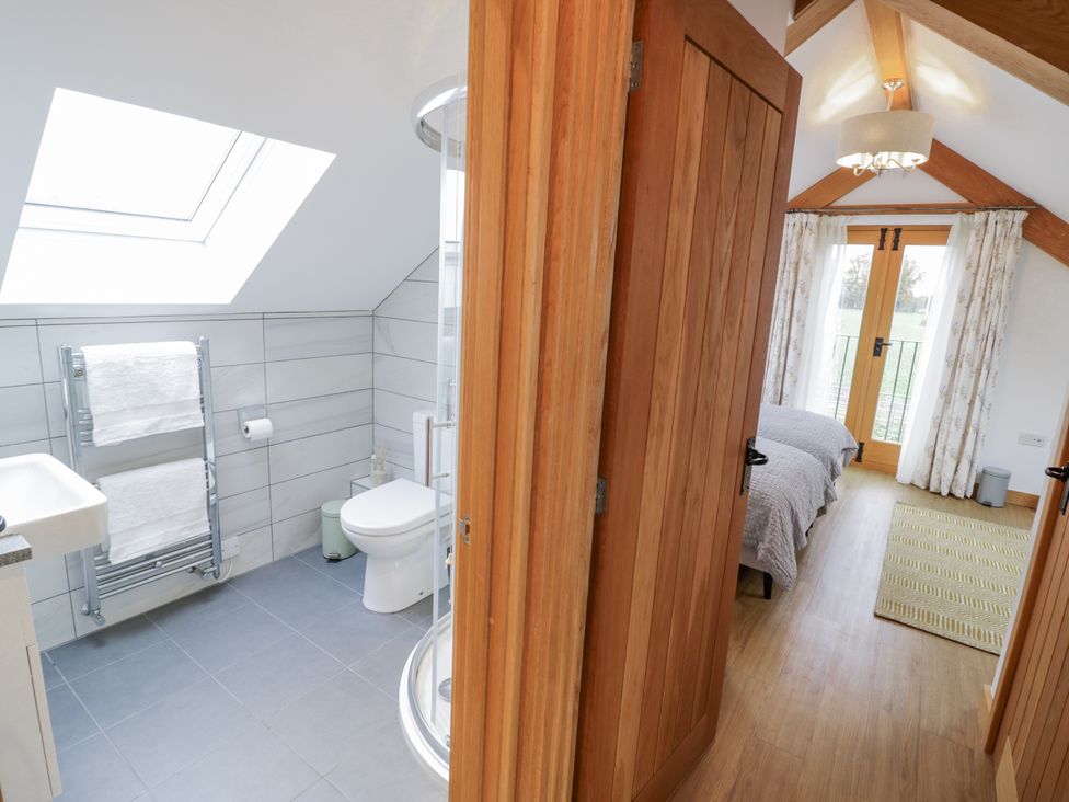 A bathroom with a shower and a toilet at Cedar Barn 
