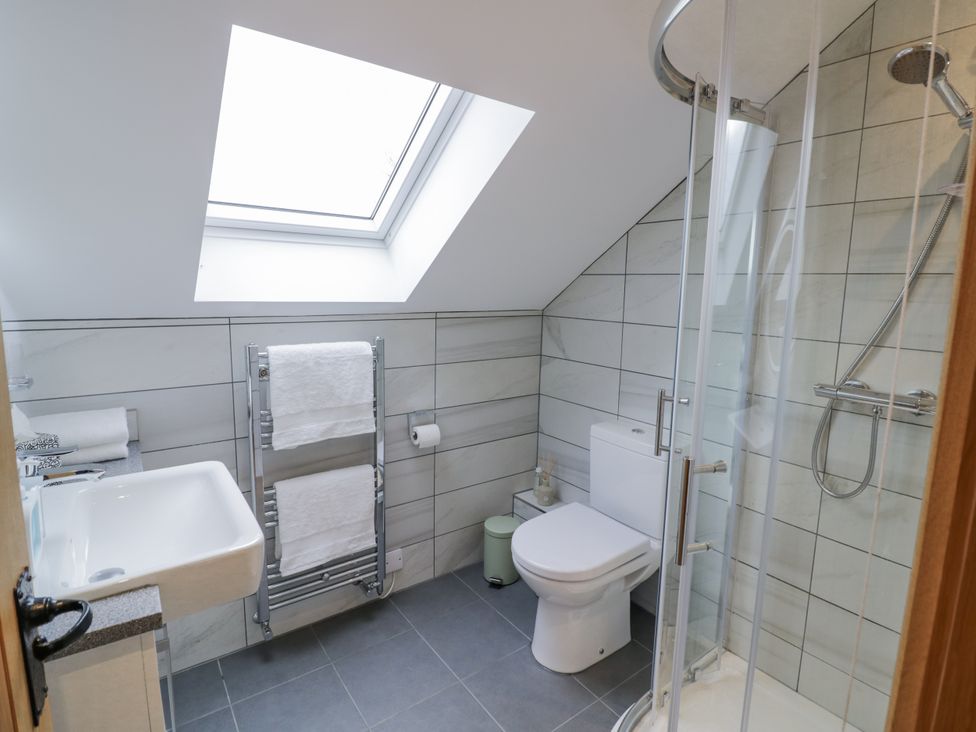 A bathroom with a shower, toilet, and sink at Cedar Barn
