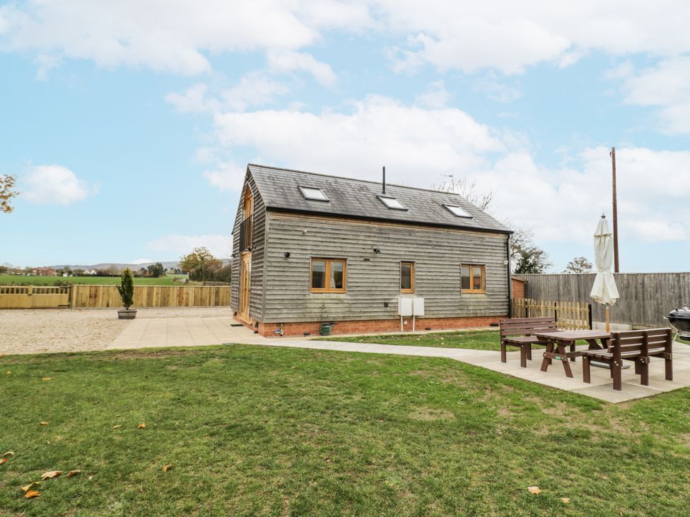 A house with a yard and patio furniture at Cedar Barn