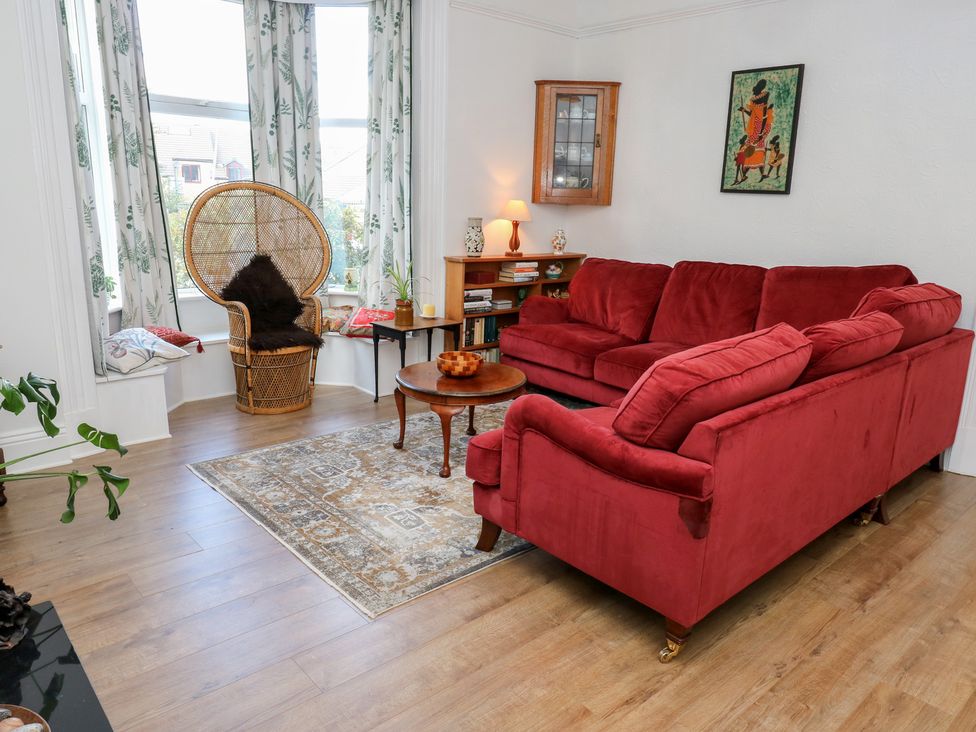 A living room with a red sofa and a coffee table at 27 Calton Terrace in Skipton