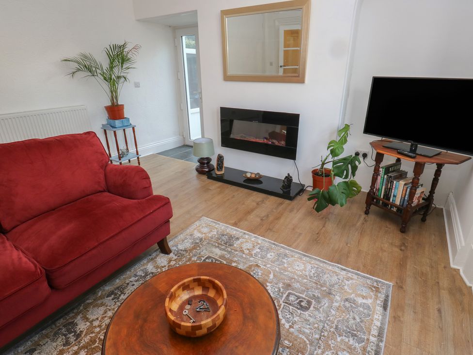 A living room with a red sofa and coffee table at 27 Calton terrace in Skipton