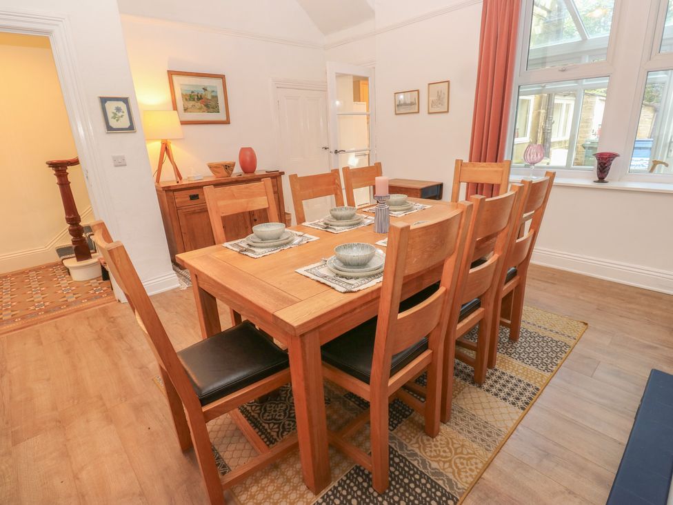 A dining room with a table and chairs arranged at 27 Calton terrace in Skipton