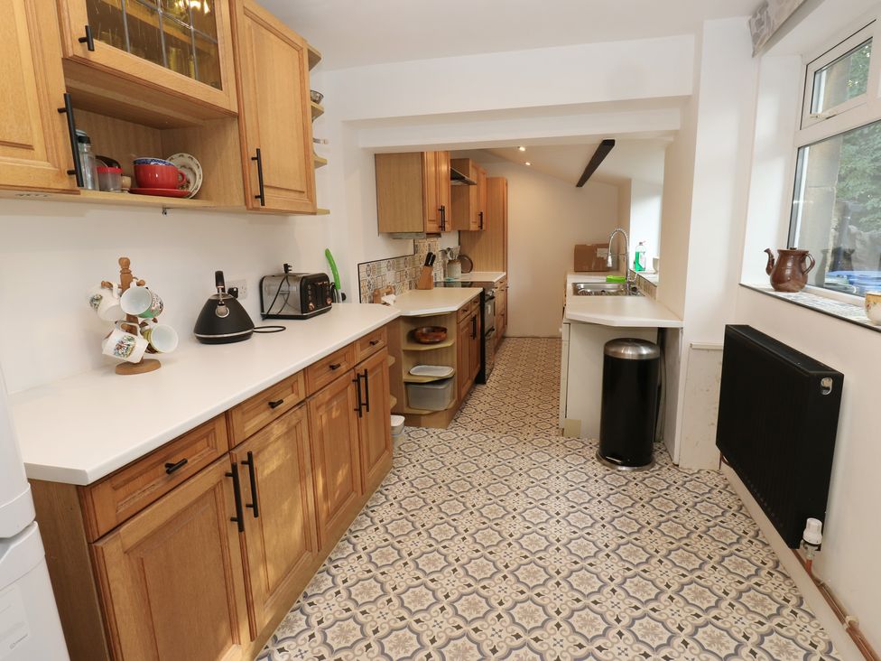 A kitchen with wooden cabinets and appliances at 27 Calton terrace in Skipton
