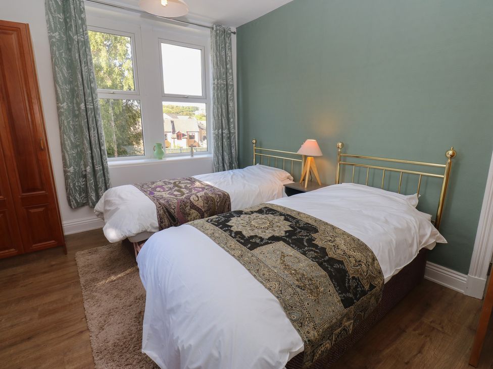 A bedroom with two beds and a cabinet at 27 Calton terrace Skipton