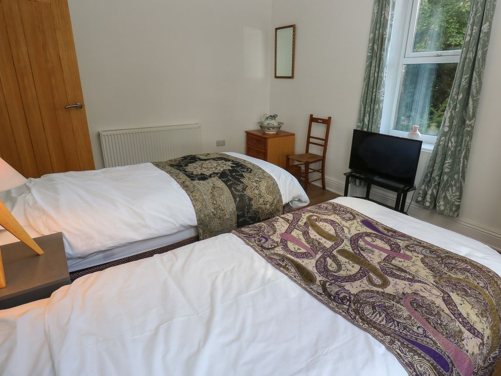 A bedroom with twin beds and a television at 27 Calton terrace in Skipton