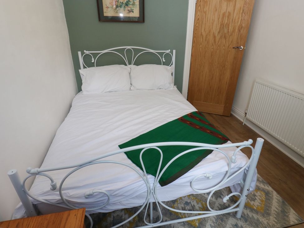 A bedroom with a bed and door at 27 Calton terrace Skipton