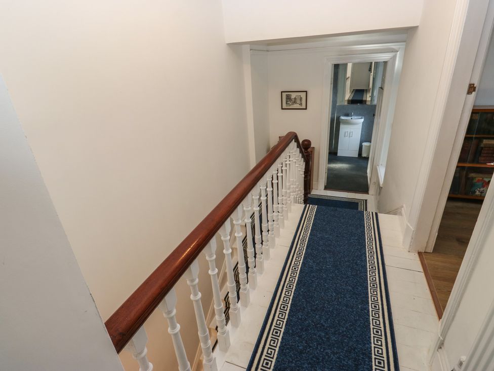 A hallway with a staircase and doorway at 27 Calton terrace in Skipton