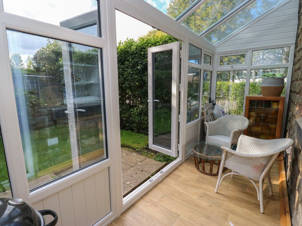 A conservatory with chairs and a glass table at 27 Calton terrace in Skipton